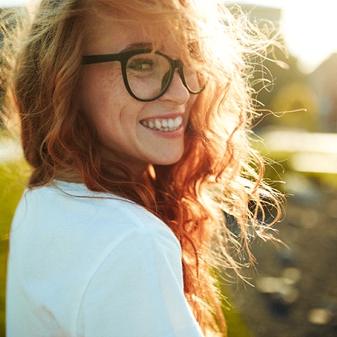 Red haired woman with glasses smiling