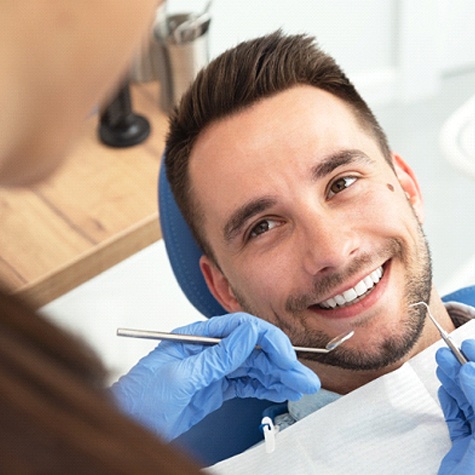 A man having his teeth checked and cleaned by a dentist