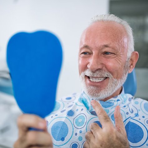 senior man admiring his new dental implants in Doylestown 