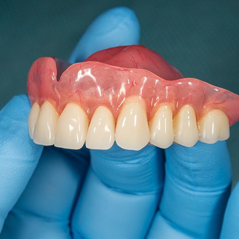 Dentist holding a full denture