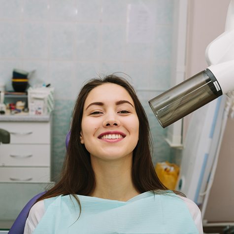 Smiling woman leaning back in dental treatment chair