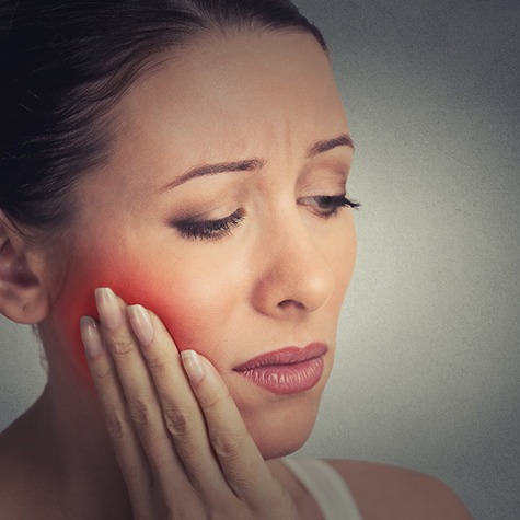 Woman experiencing tooth pain in Doylestown