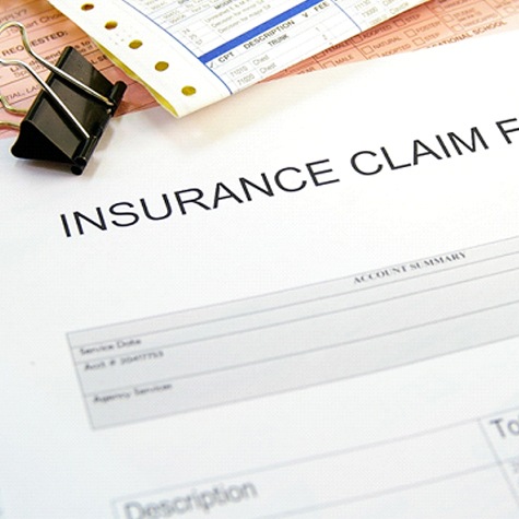 Close-up of insurance claim form on top of other documents