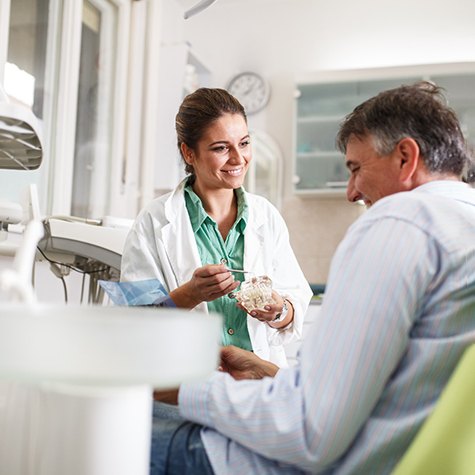 a dentist speaking with a patient about implant salvage