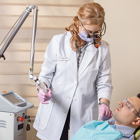 Doctor Kandov using soft tissue laser dentistry tool